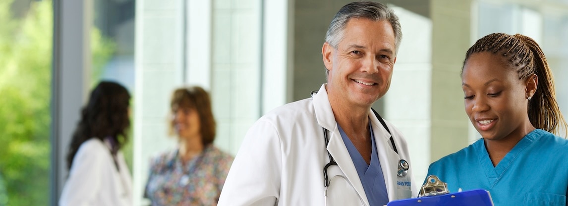 physician and assistant smiling