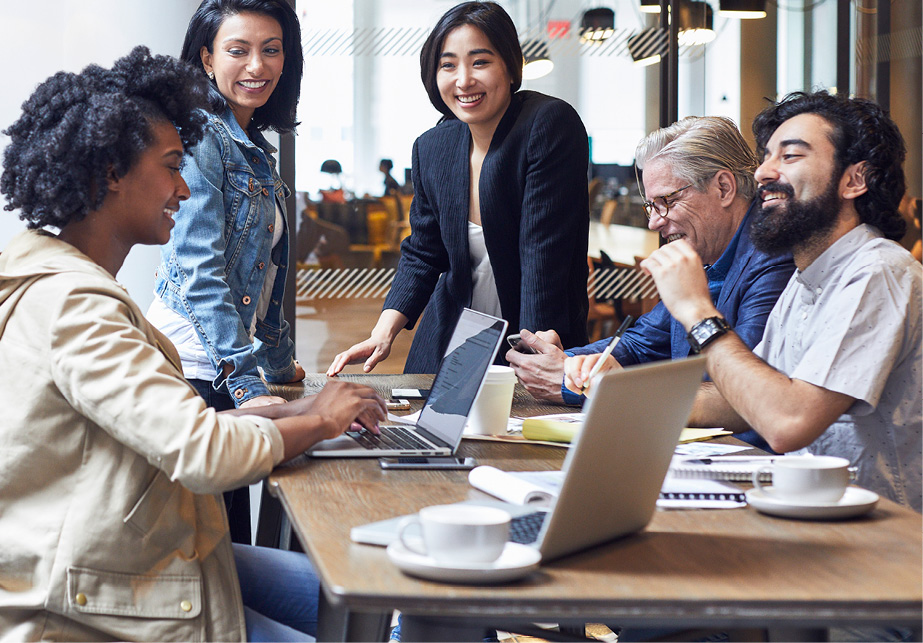 Smiling group of professionals working together at a coffee shop