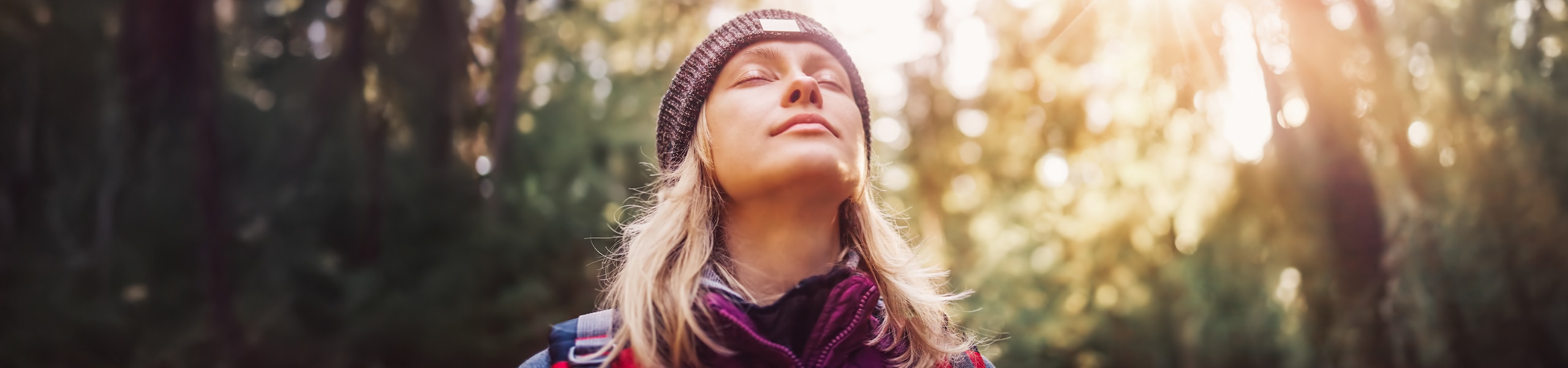 Person breathing deeply while meditating outside