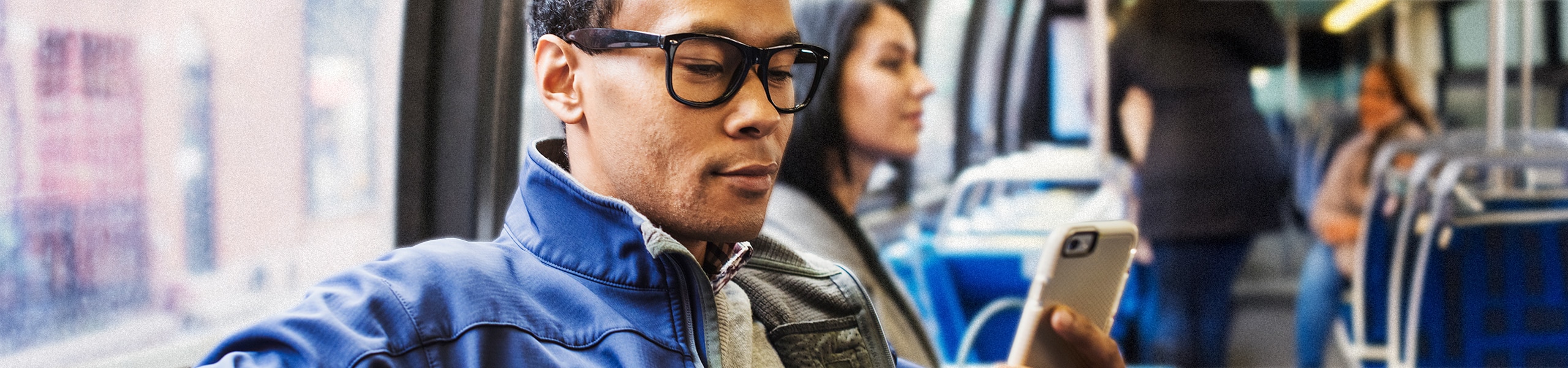 Person looking at their phone while sitting on a bus