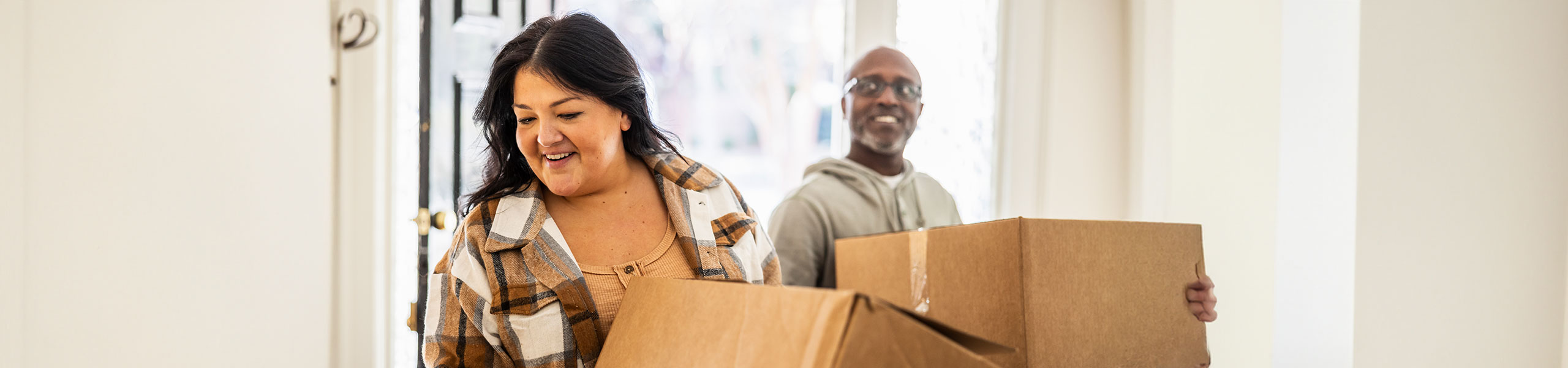 A couple holding moving boxes