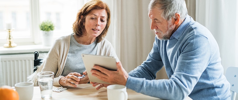 A couple using their tablet to review medications online