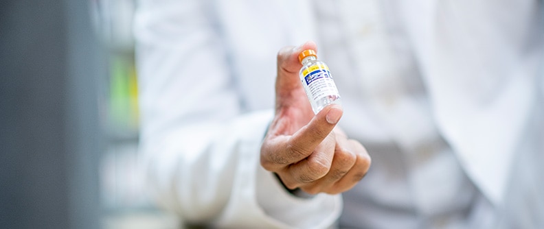 A pharmacist holds a vial of insulin