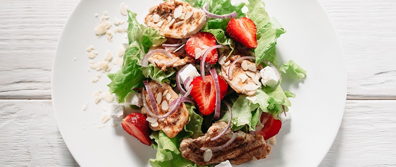 A plate of salad and fruit