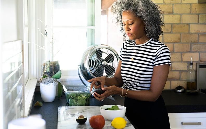 A woman makes a salad in a kitchen