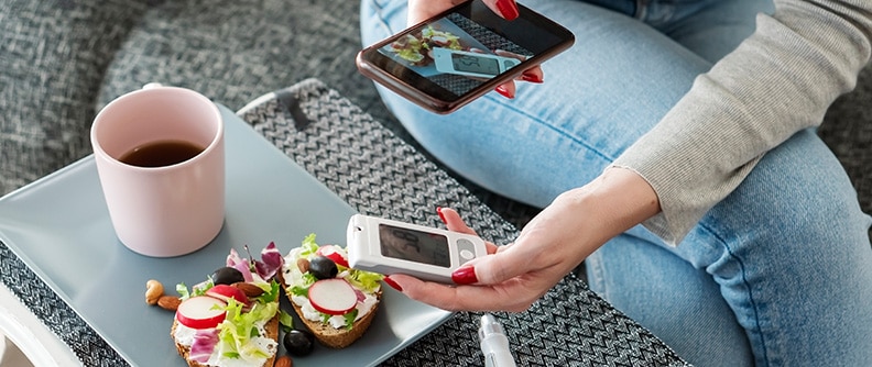 A woman takes a photo of her meal and her glucometer reading