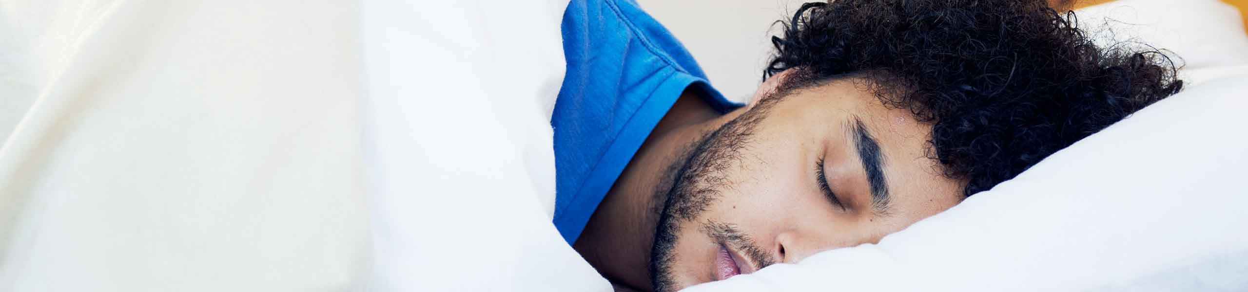 man in bed sleeping on his side