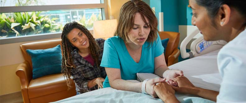 Woman in labor with birthing partner and doctor.