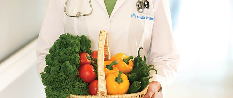 Kaiser Permanente doctor holding basket of fresh vegetables.
