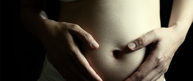 Beautiful close up of pregnant woman's touching belly and waiting until new life born.