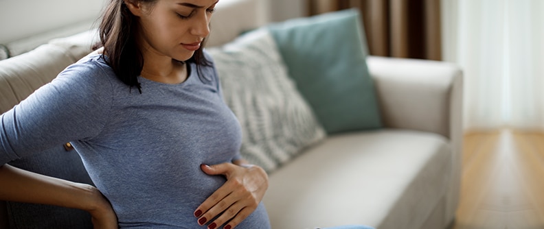 Young pregnant woman suffering from backache.