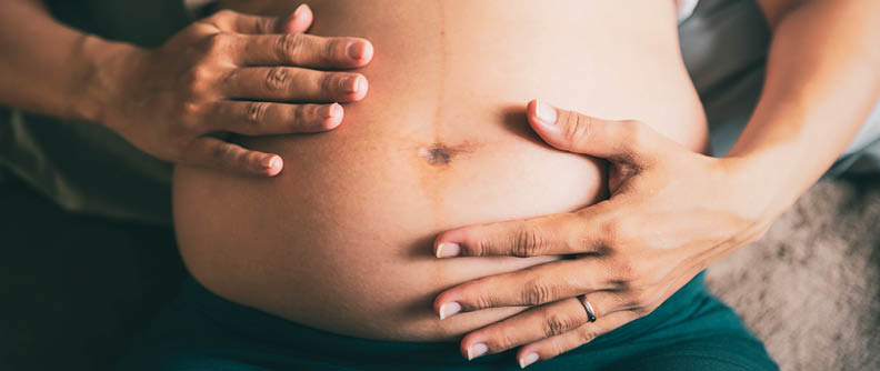 Pregnant woman belly at home.