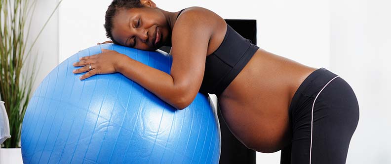 African American woman using Swiss Ball during labour.