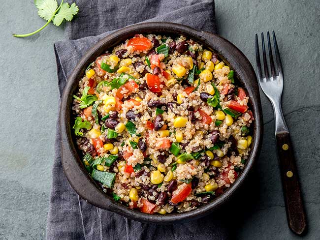 Mexican black bean corn quinoa salad in clay bowl 