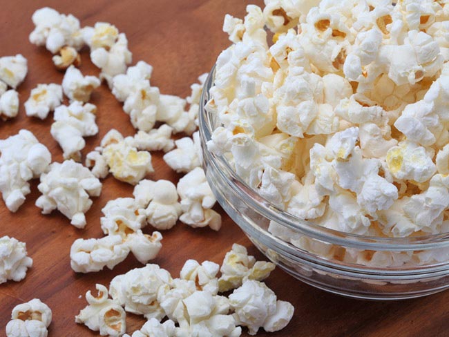 An overflowing bowl of popped popcorn.
