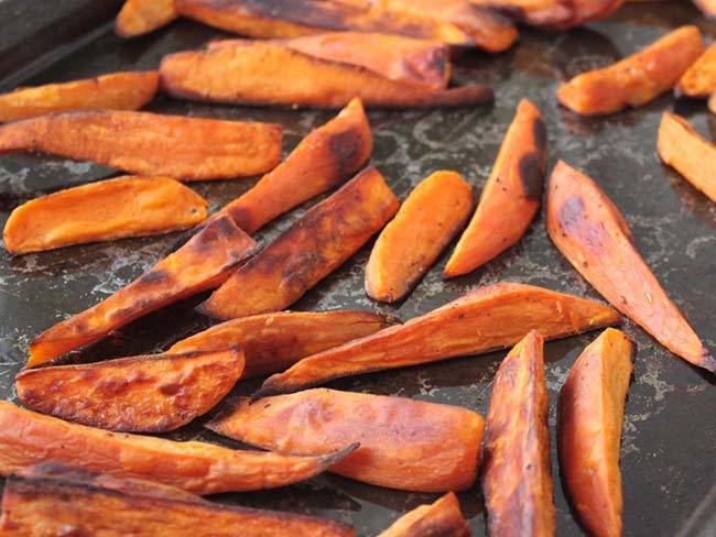 Roasted sweet potato fries on a baking sheet.