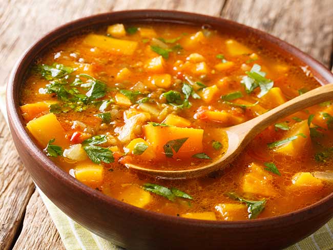 Pasta e Fagioli garnished with basil served with whole wheat bread