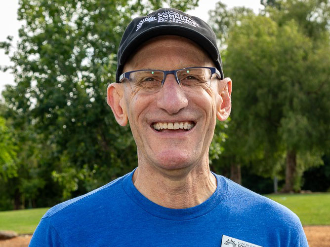 A smiling middle-aged man wearing a baseball cap.