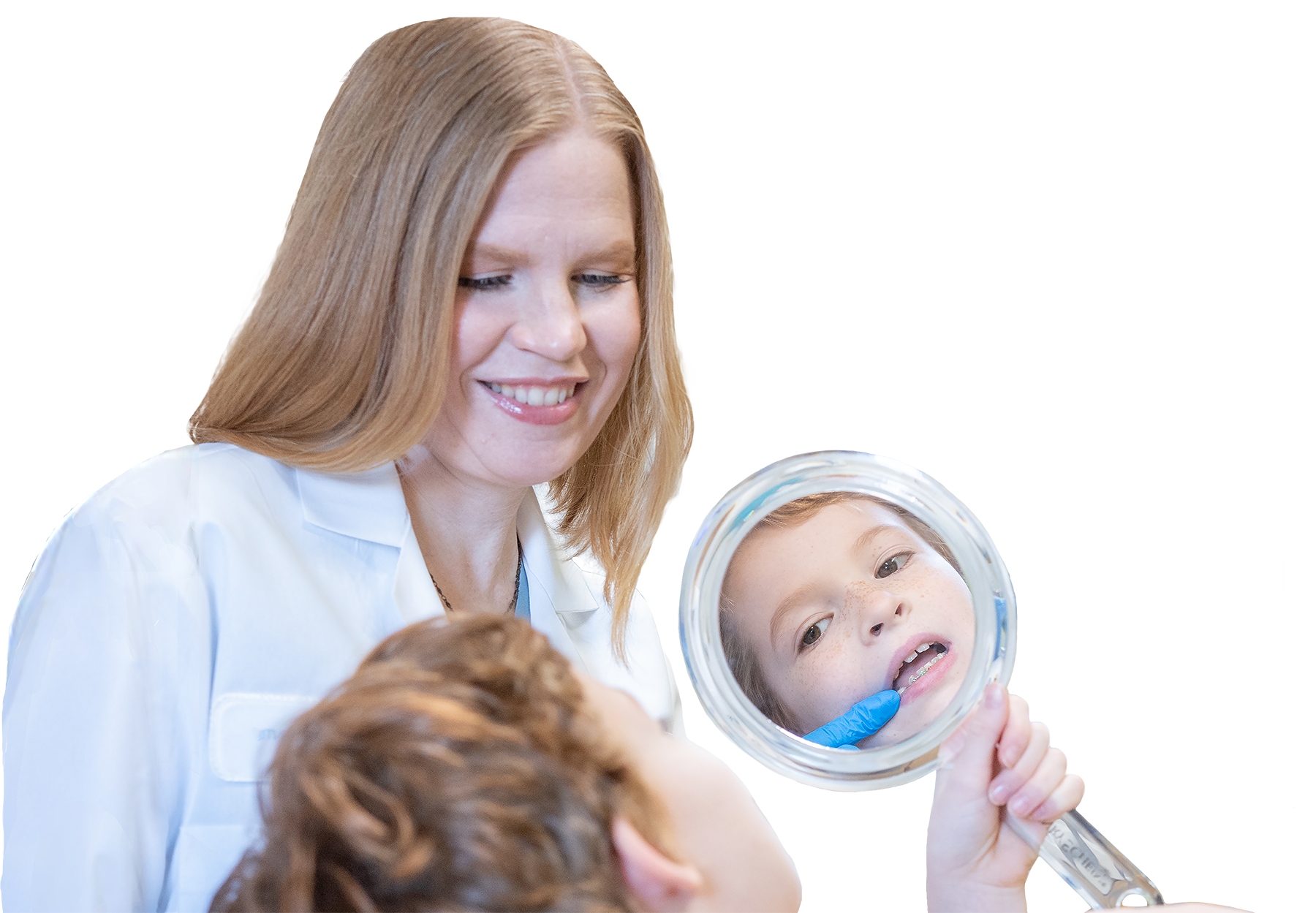 child looking in mirror at teeth in dentist’s office