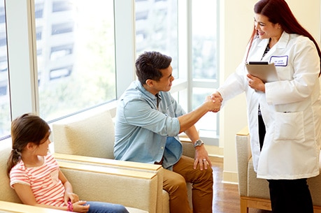 Nurse speaking with parent and child in medical office