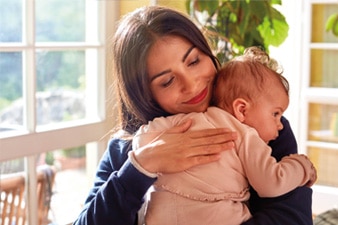 Parent embracing baby