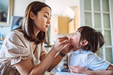 Parent giving their child an at-home COVID-19 test