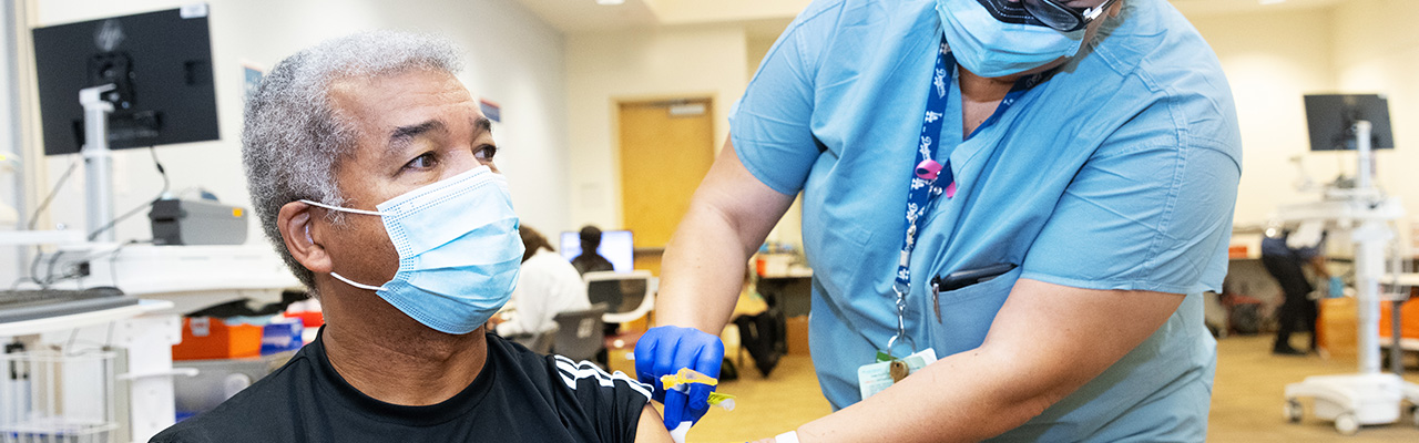 Nurse preparing a patient’s arm for vaccination. 