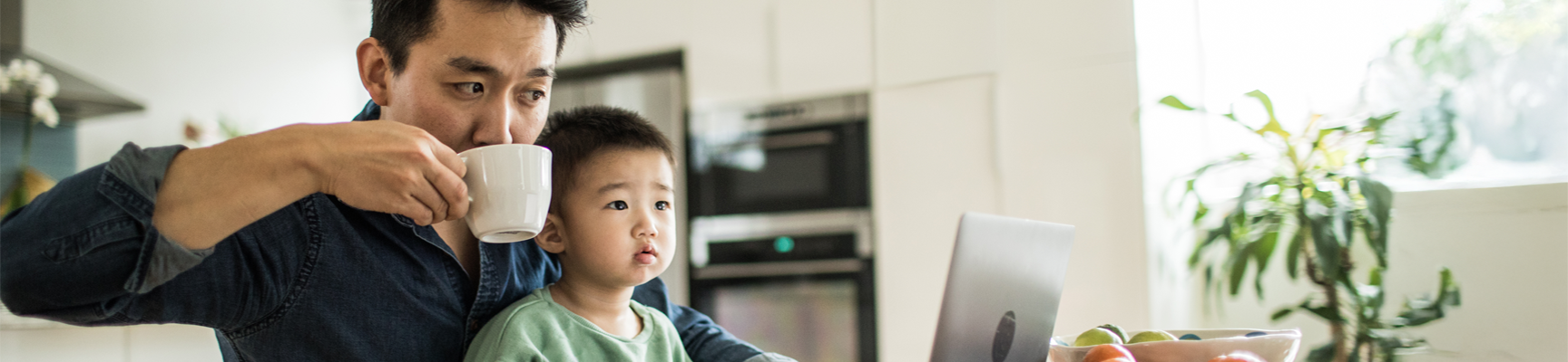 Person with a child looking at a laptop