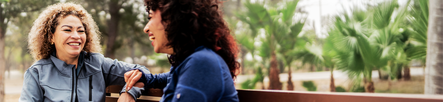 Two people talking on a park bench