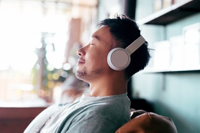 Person listening to headphones with eyes shut