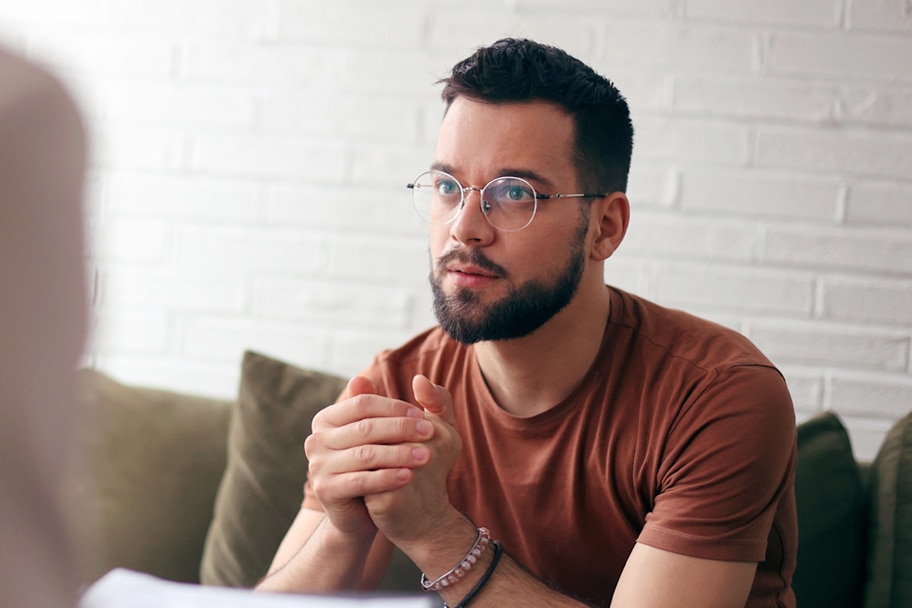 Person sitting with hands folded