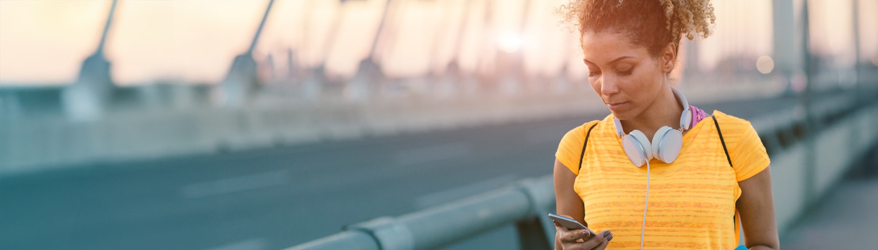 Runner pausing on a bridge to check her phone