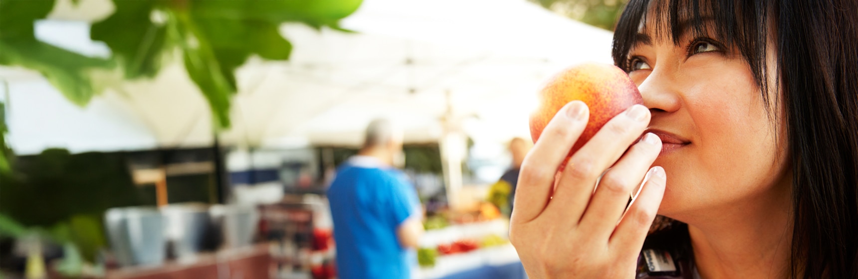 Shopper checking piece of fruit at market