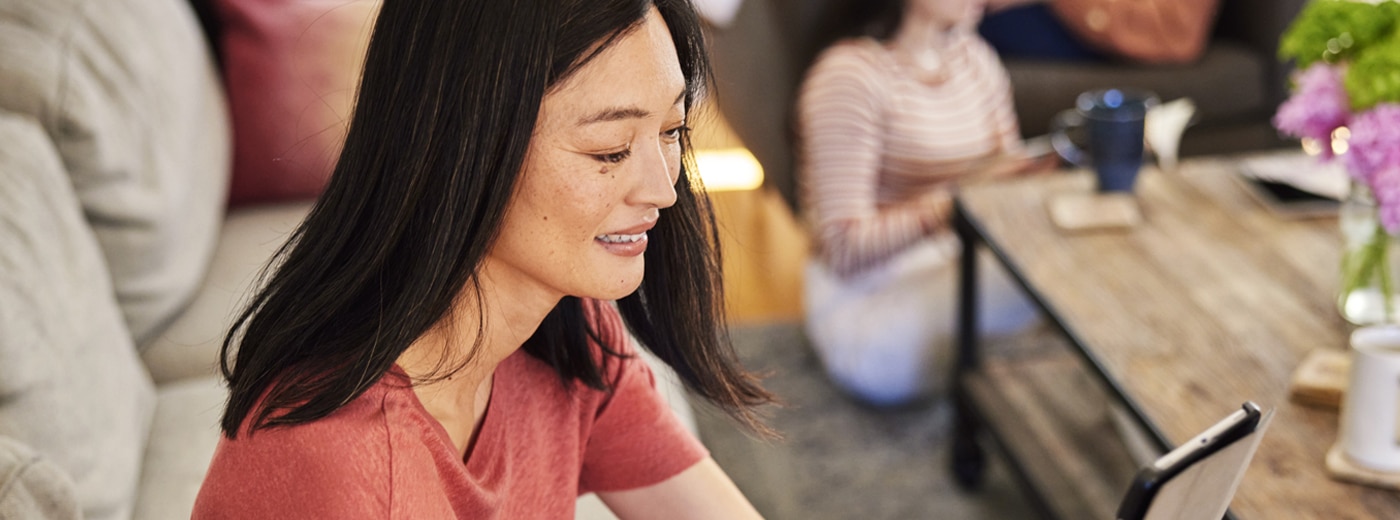 Happy woman managing her health plan on a tablet at home