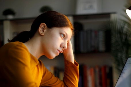 Young person resting their head in their hand