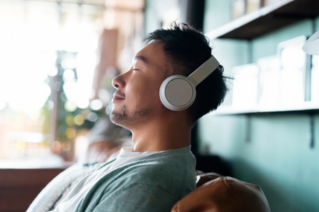 Young person wearing headphones with eyes closed