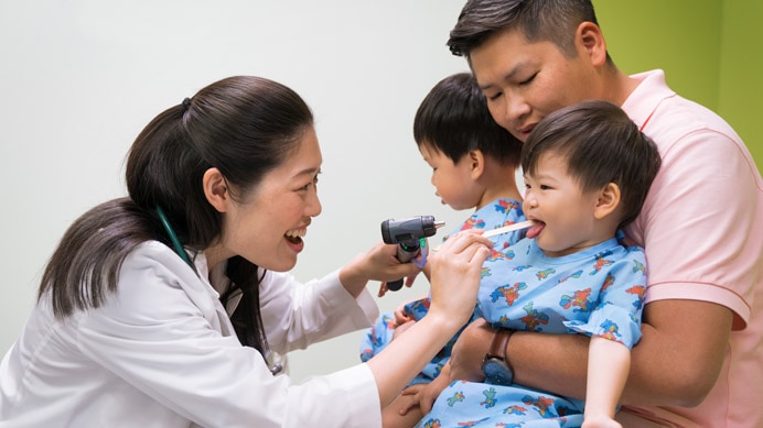 Doctor examining two smiling children