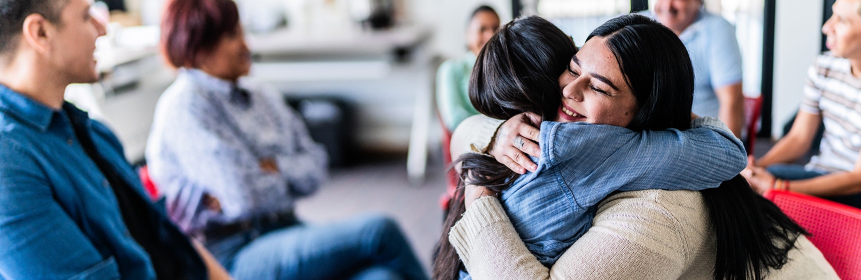 Two people hugging at a community group meeting