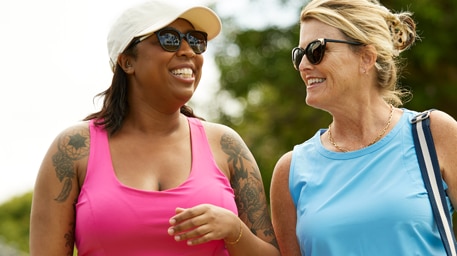 2 people walking in nature and having a conversation