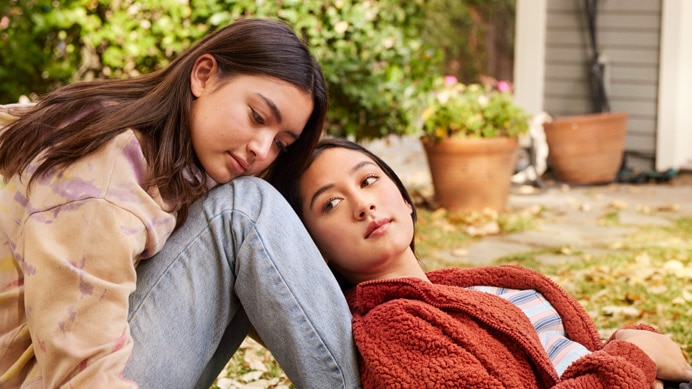 2 young people sitting together on the grass