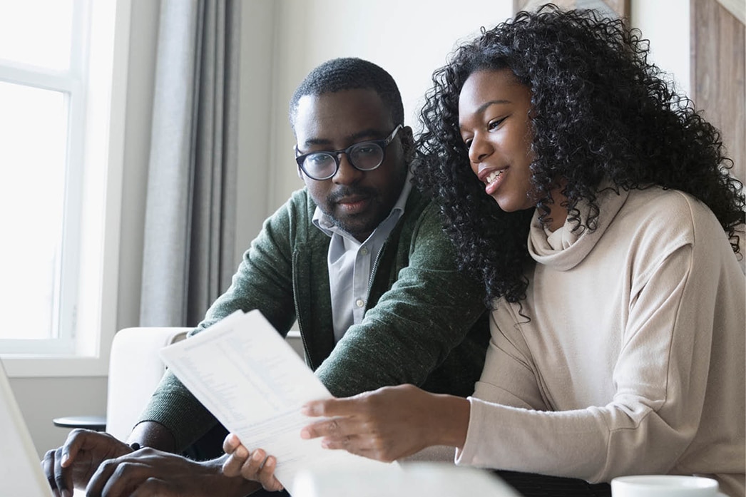 Couple looking at papers together on couch