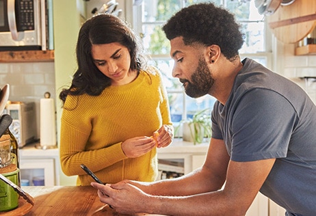 Couple looking at smartphone and making decisions together