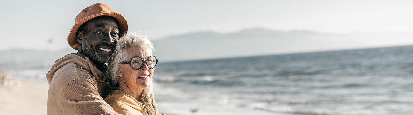 a man and a woman in costume at the beach