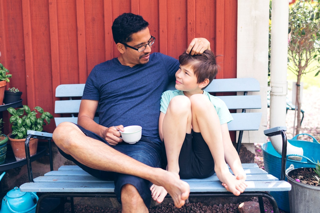 Parent and child talking on an outdoor bench