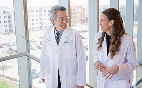 Two Kaiser Permanente doctors walking and talking in a medical office