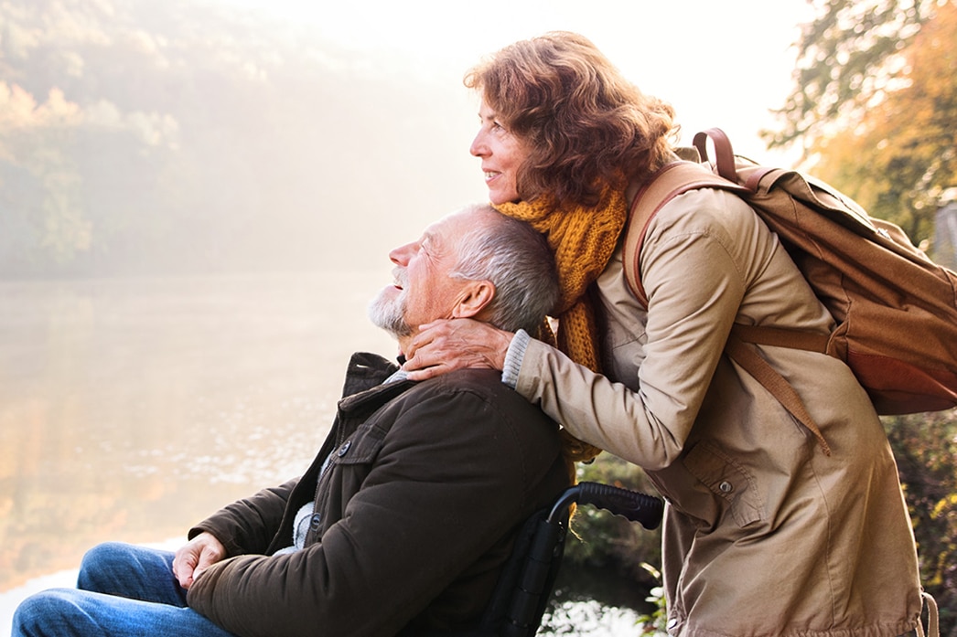 Two people leaning into each other and enjoying view of a lake