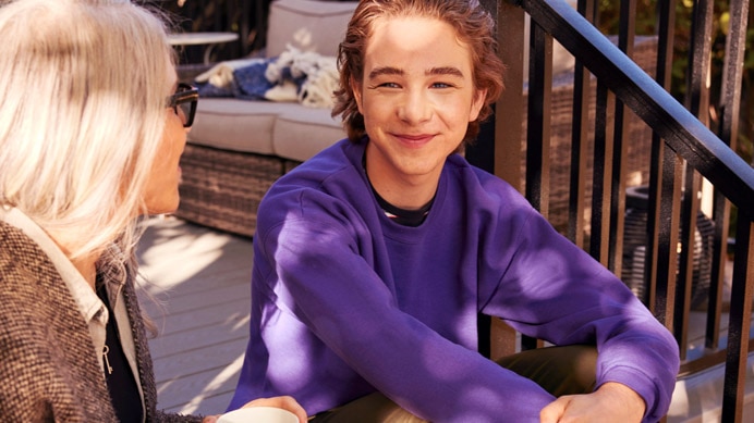 Young person smiling and talking with an older person