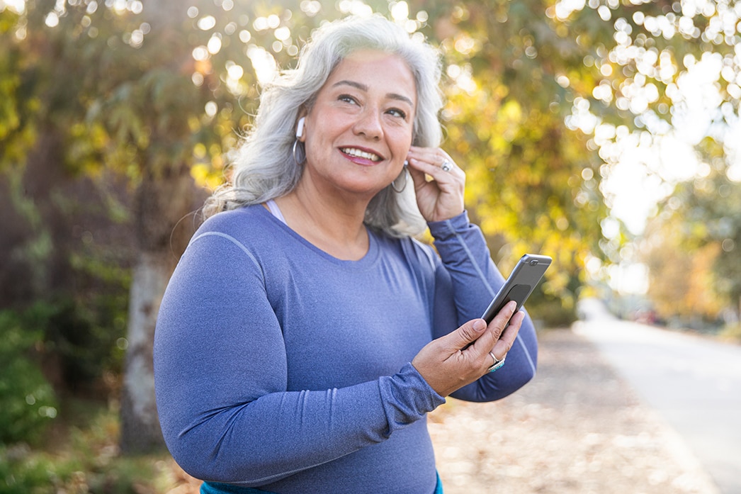 A person smiling while putting in their earbuds