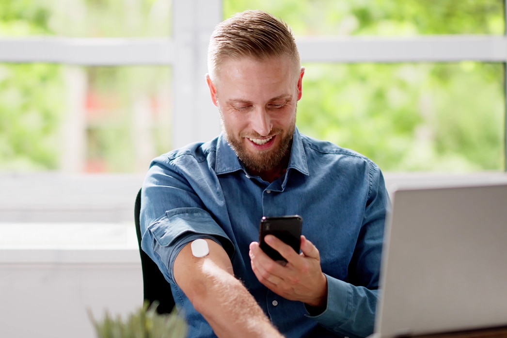 A person using a phone to monitor their diabetes