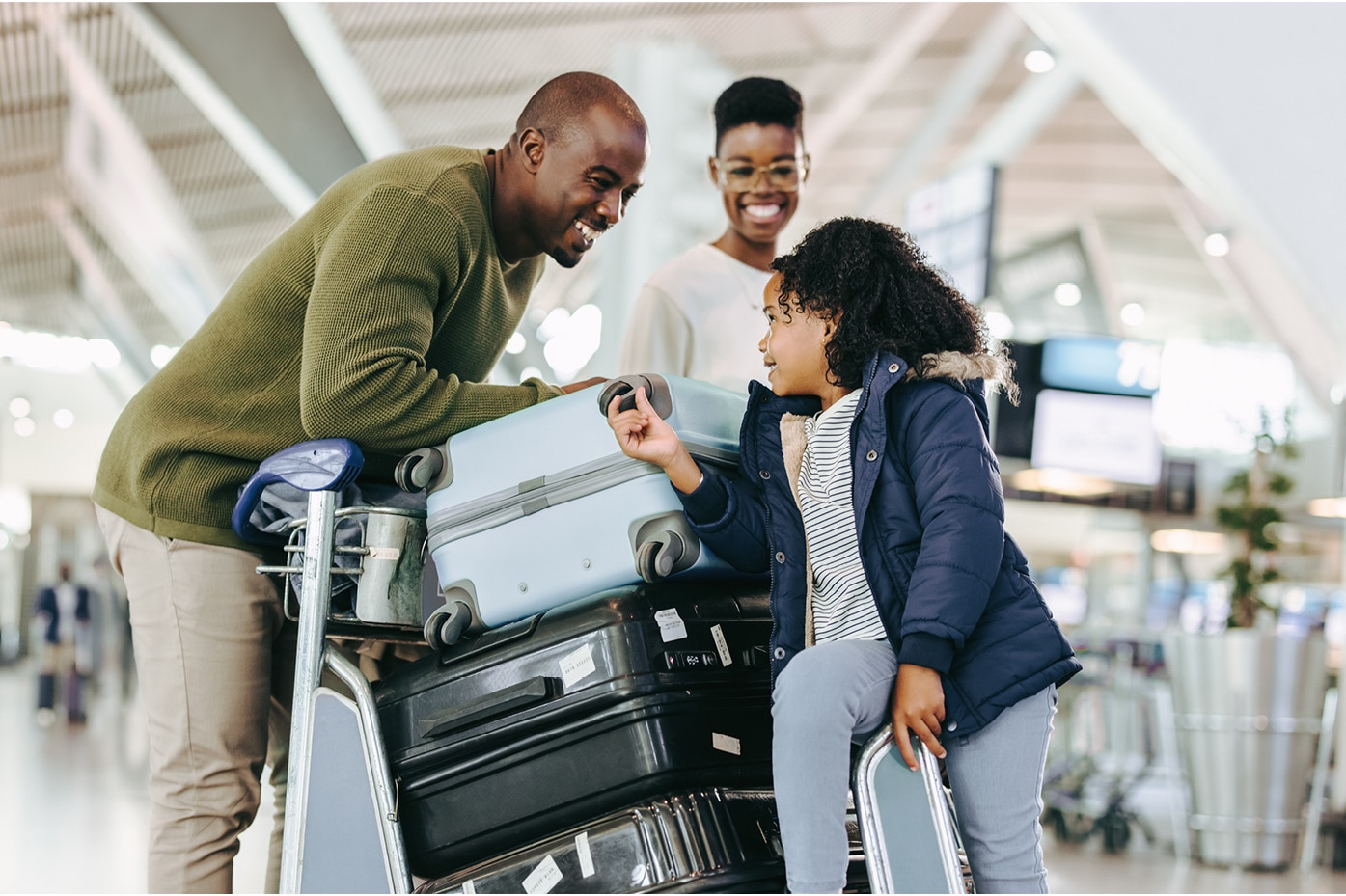 Family moving luggage through airport